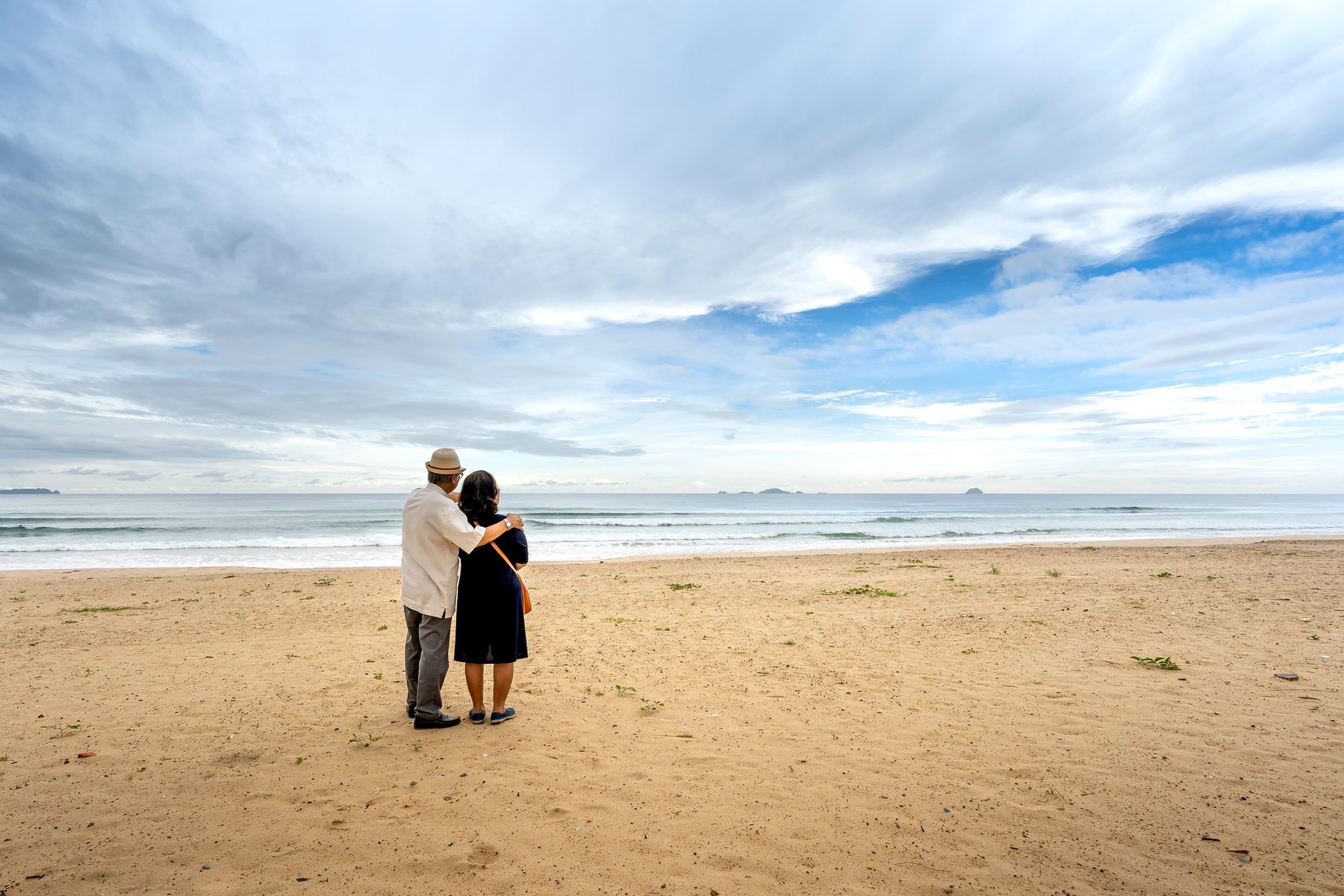 Casal contempla o mar, símbolo de tranquilidade e futuro protegido